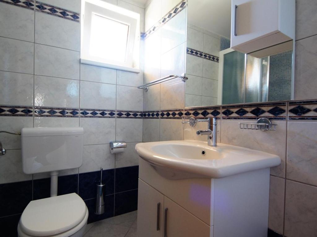 马林斯卡Apartment Malinska 33的一间带水槽和卫生间的浴室以及窗户。