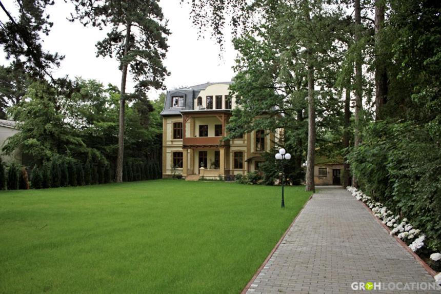 柏林酷尔孜别墅酒店的前面有绿色草坪的大房子