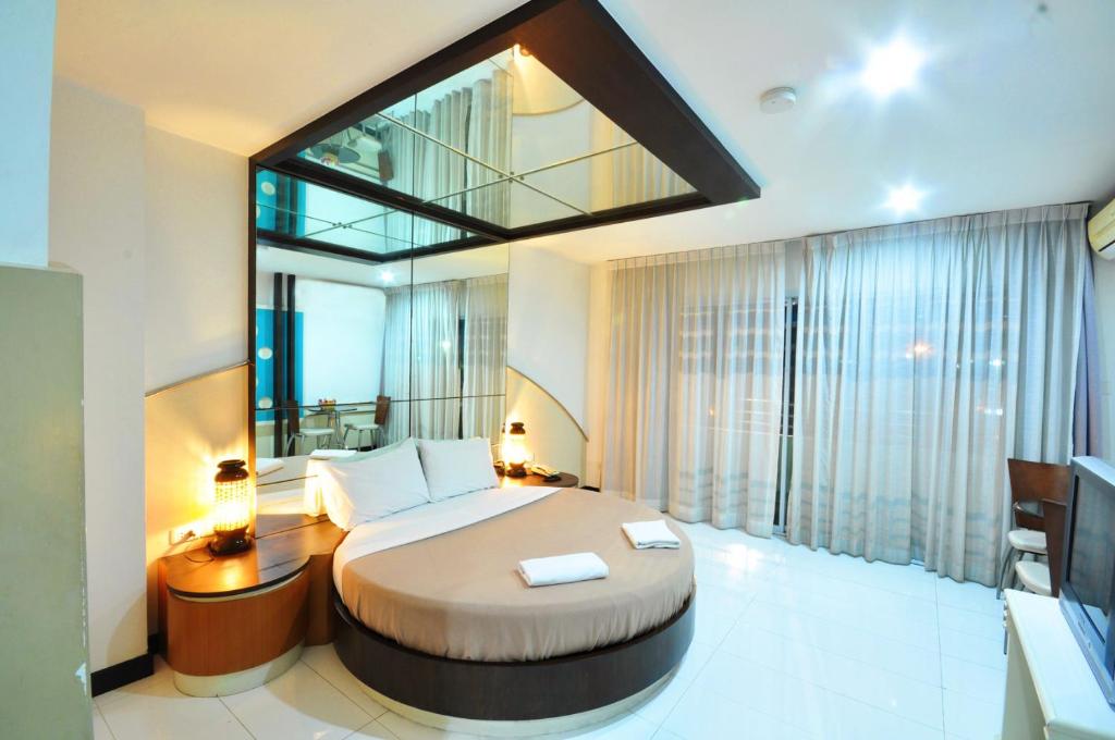 合艾合艾大酒店 的一间卧室设有一张大床和一个大窗户