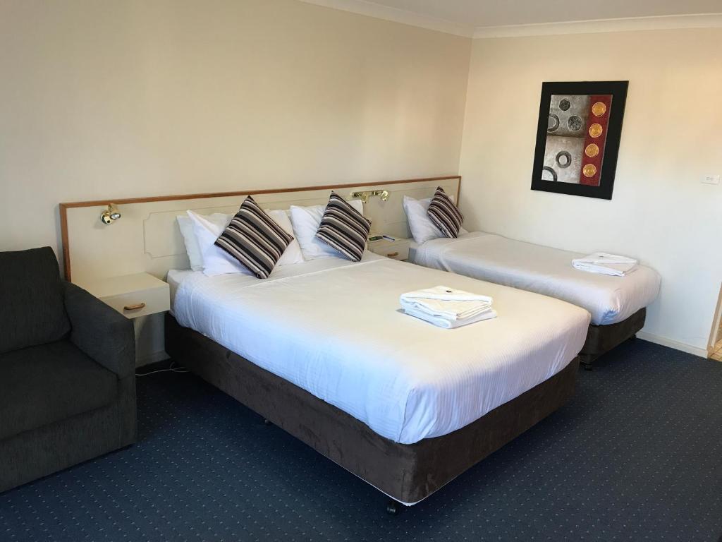 奥兰治奥兰戈汽车旅馆的酒店客房,配有两张床和椅子