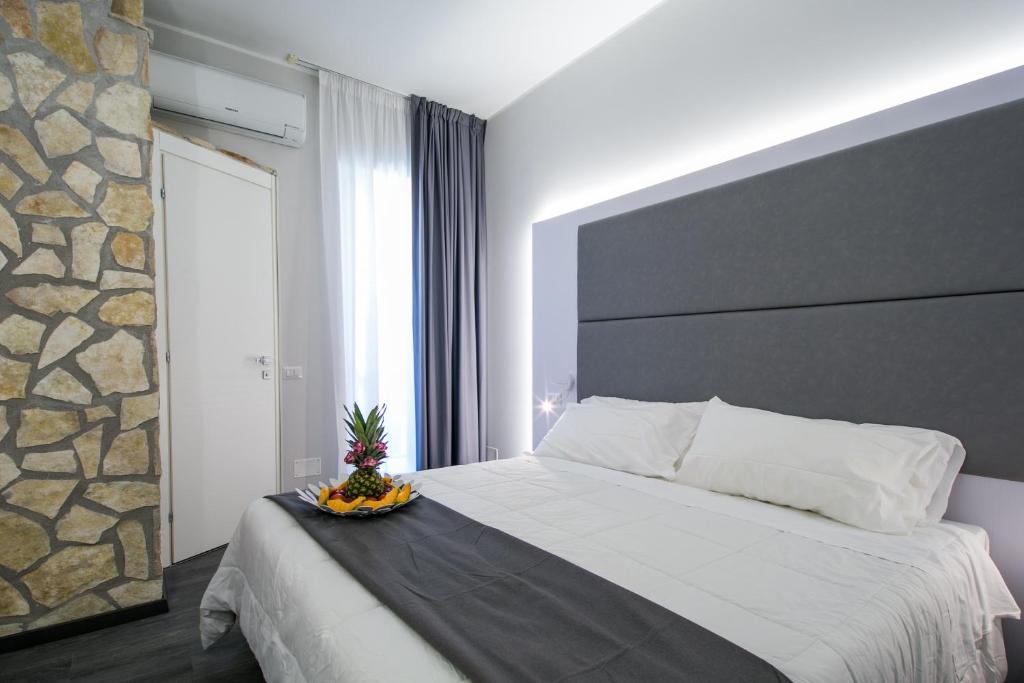 塔尔奎尼亚拉托拉西亚酒店 的一间卧室设有一张带石墙的大床