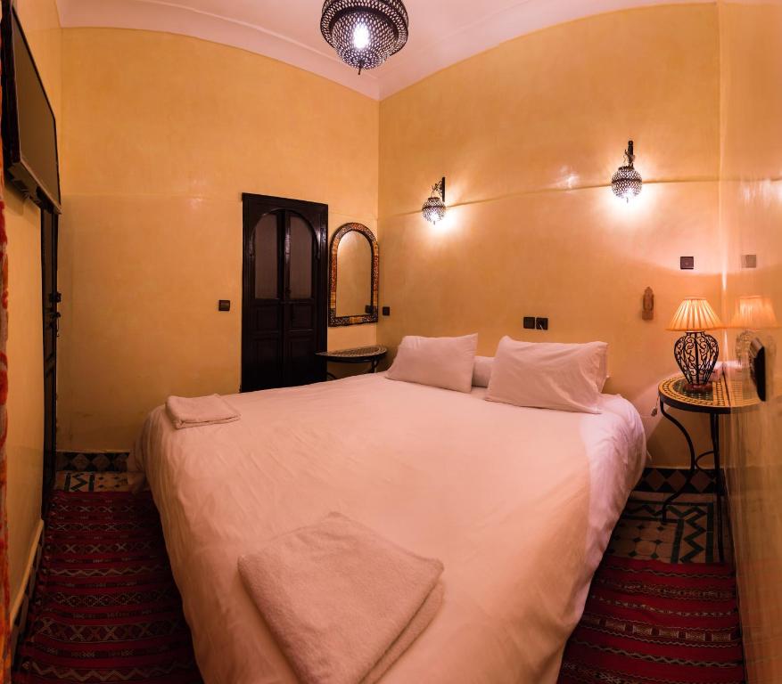马拉喀什里亚德奥马尔庭院旅馆的卧室配有一张白色大床