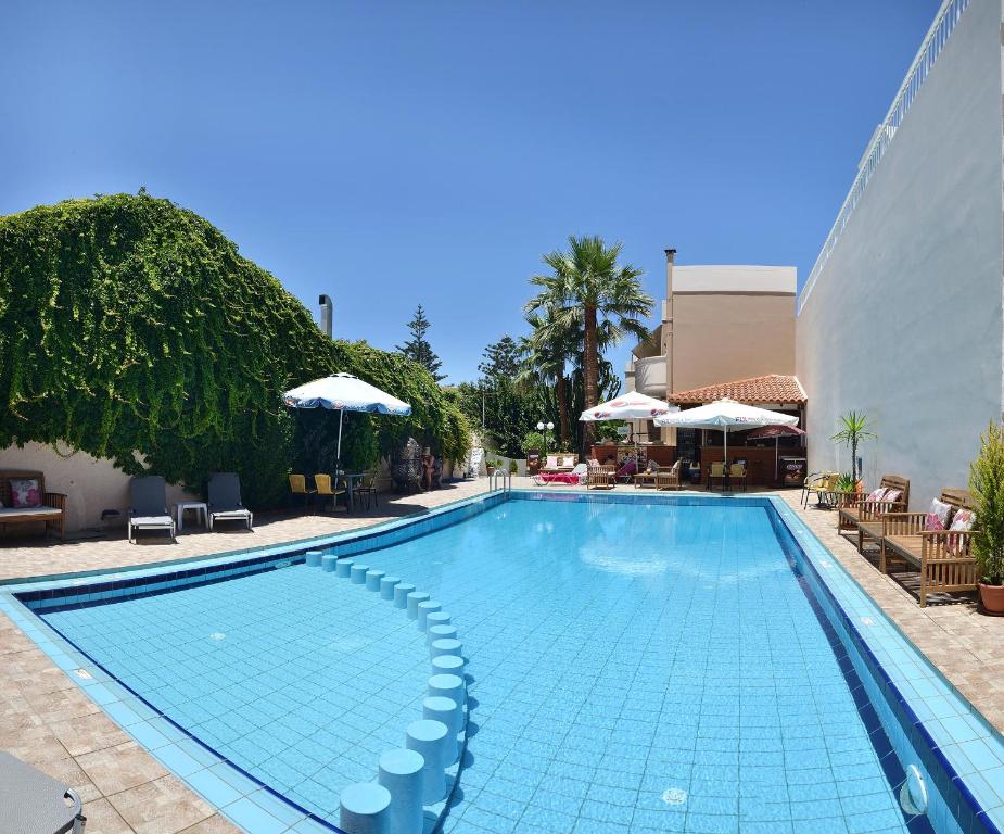 埃亚玛琳娜奈奇多Akatos Hotel的一个带椅子和遮阳伞的大型游泳池