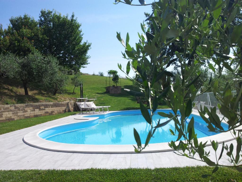 托伦蒂诺Podere Del Fagiano的庭院内的游泳池,配有桌子