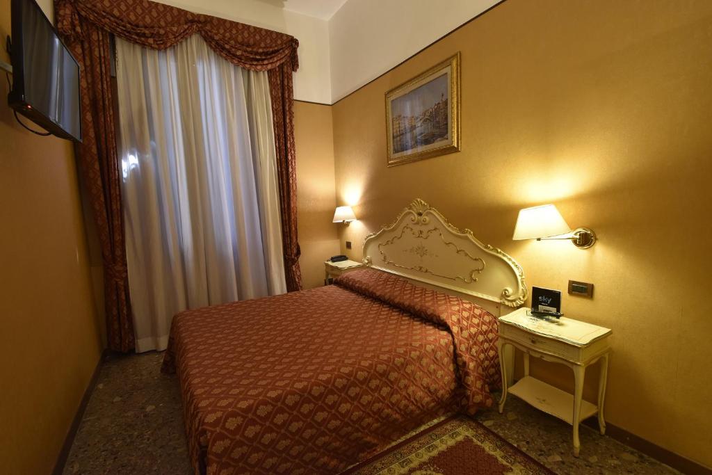 威尼斯洛坎达波斯特维奇酒店的酒店客房设有床、桌子和窗户。