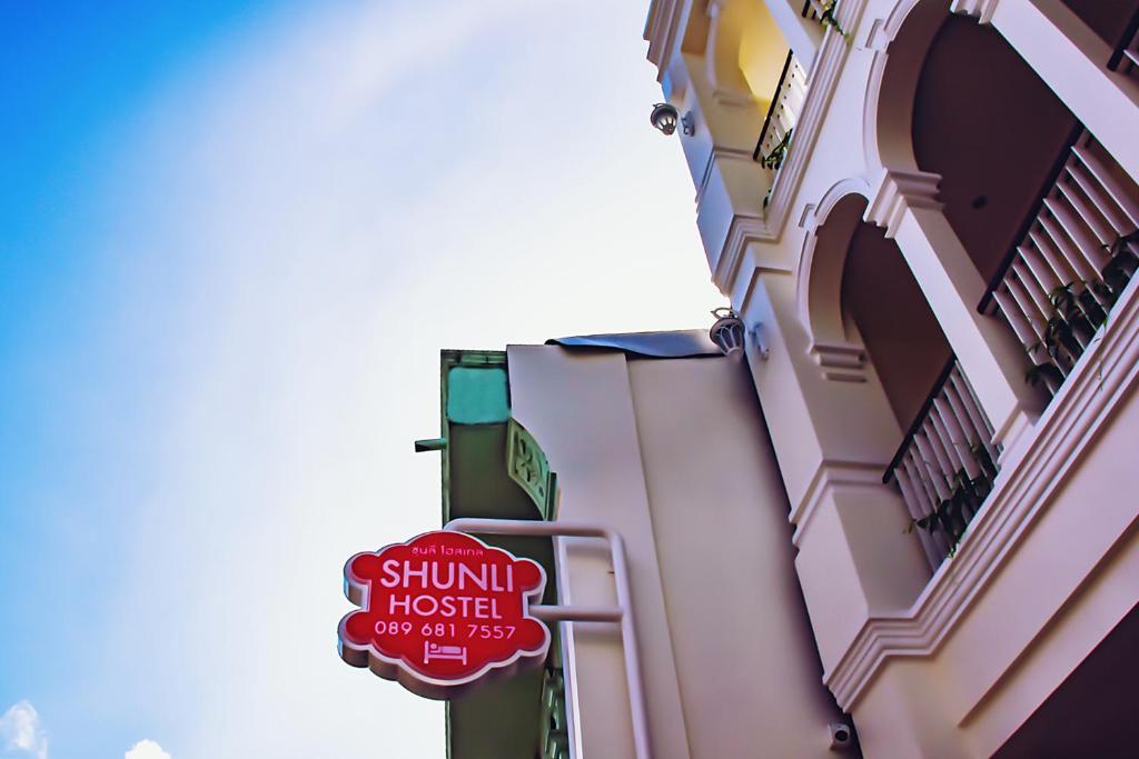 普吉镇Shunli Hotel - SHA Extra Plus的建筑物一侧的标志