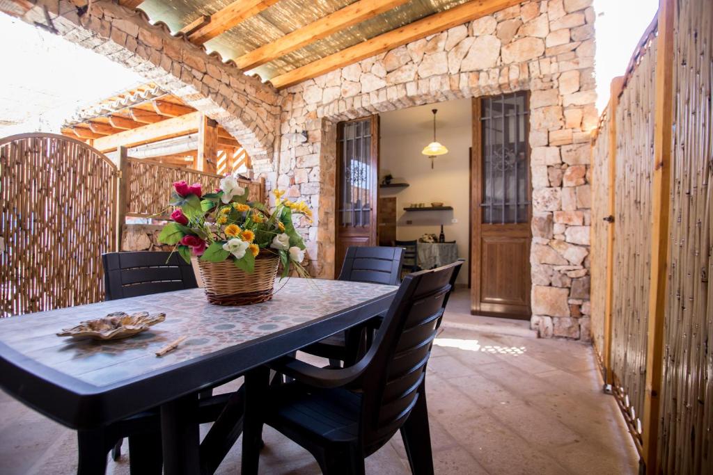 莱乌卡Pietra del Mediterraneo的用餐室,配有带鲜花篮的桌子