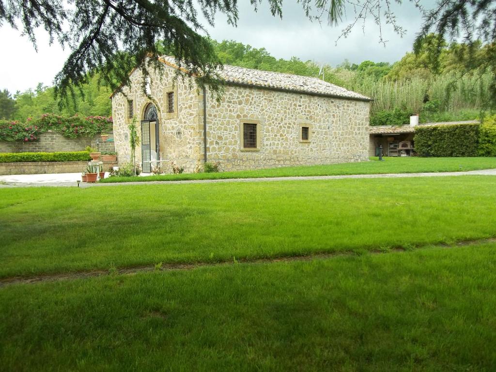 FarneseIl Mulino in Maremma的前面有草地的石头建筑