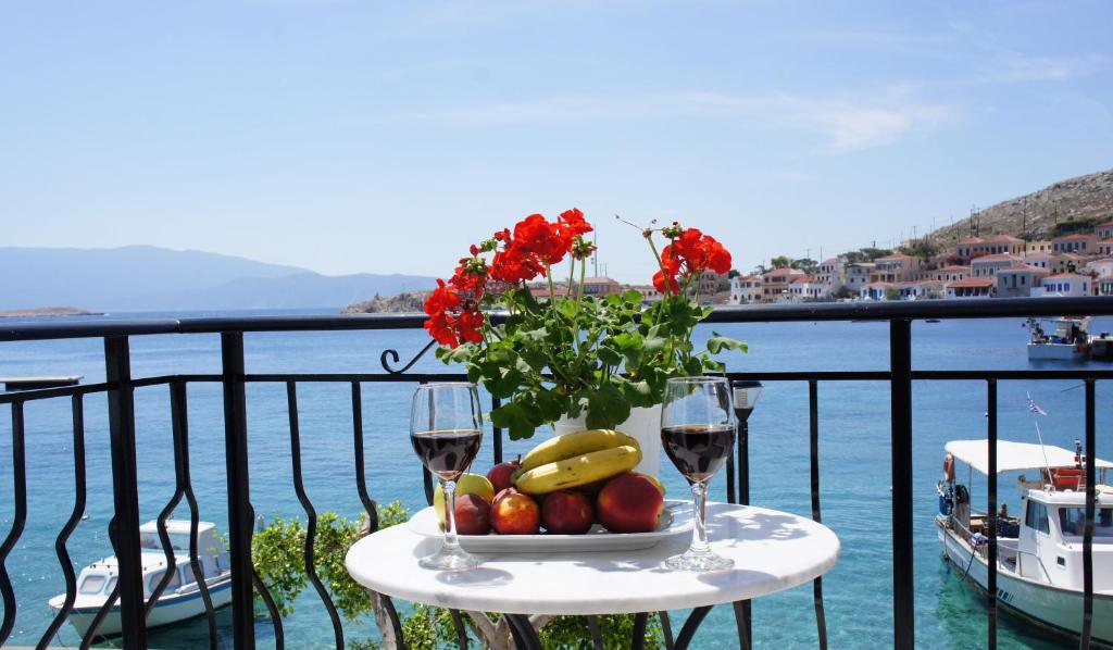 哈尔基岛Aegean View Villas的一张桌子,上面放着一碗水果和两杯葡萄酒