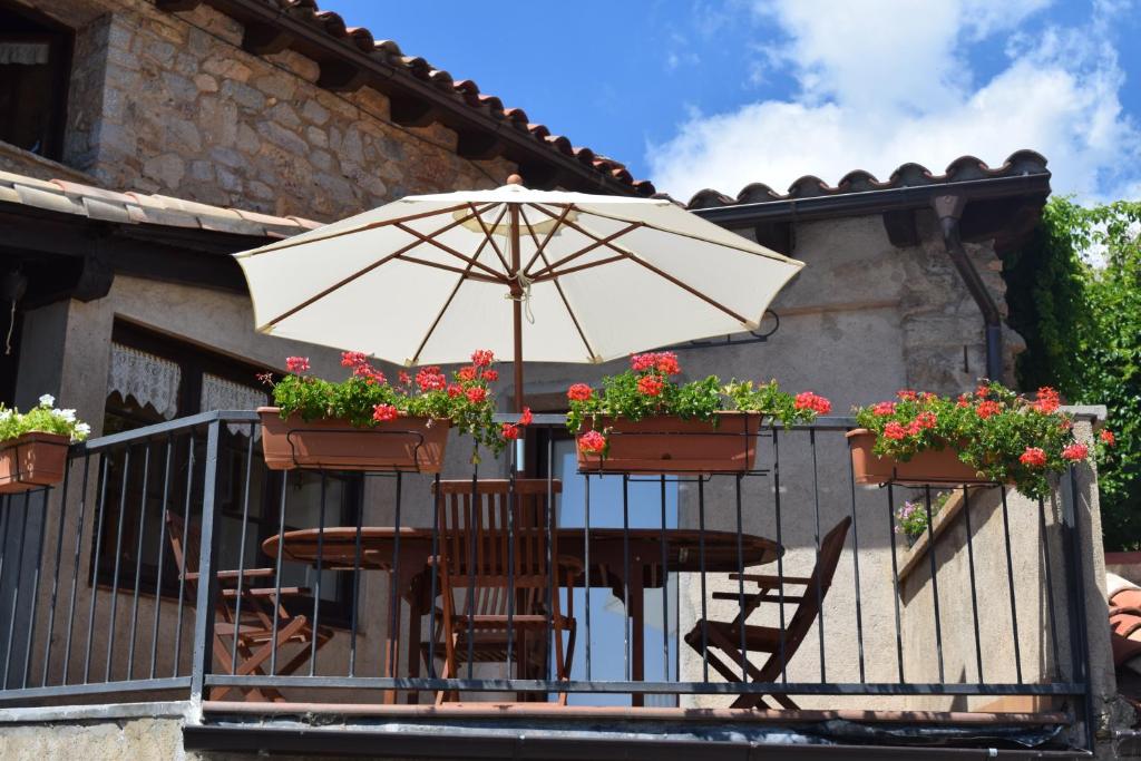努奇堡Cal Genetó的阳台配有桌椅和遮阳伞