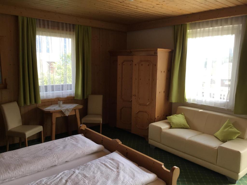 ObersdorfGästehaus Lemmerer的带沙发、床和桌子的客厅