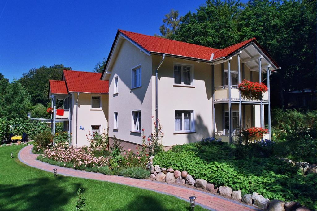 奥斯赛拜-塞林Ferienhaus zum Südstrand的一座红色屋顶的房子和一个院子