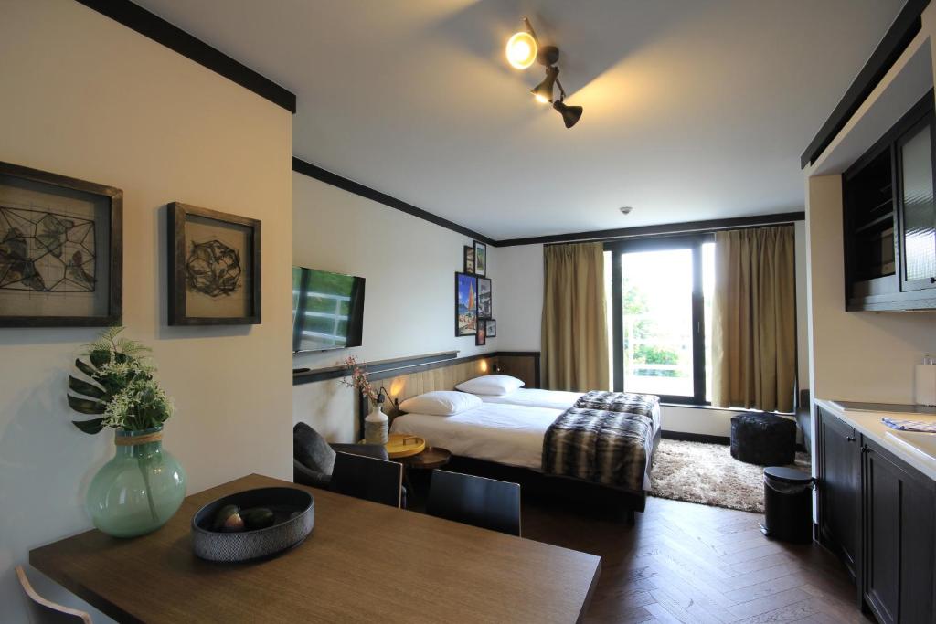 扎芬特姆布鲁塞尔机场逍遥游一室公寓的一间卧室配有一张床铺和一张桌子,还有一间用餐室