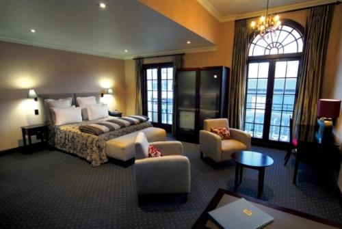 纳皮尔皇冠大酒店的酒店客房配有一张床、一张沙发和椅子。