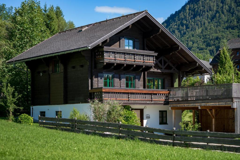 巴特奥塞Ausseer Chalet (nahe Hallstatt), Ferienhaus的一座位于山丘上的大型木屋,设有阳台