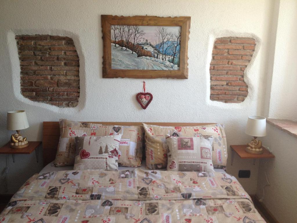 PadernoSole Luna的一间卧室配有带枕头的床铺和砖墙