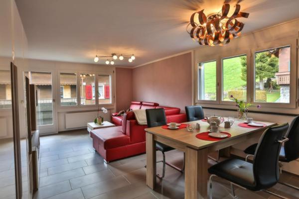 维尔德豪斯Wildhaus Weiherhof的客厅配有桌子和红色沙发