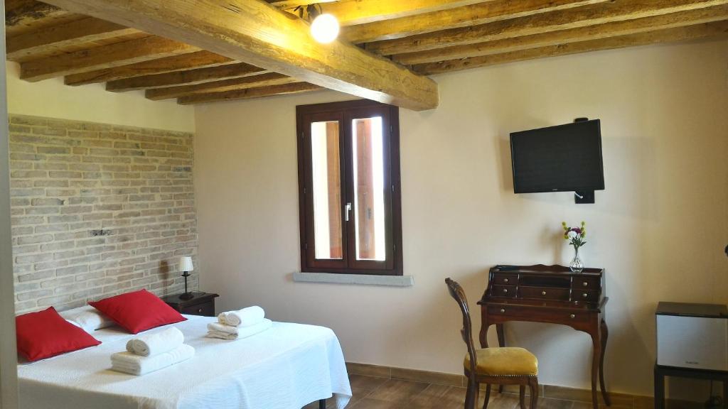 GattaticoAntico Casale Caroli的客房设有两张床、一张桌子和一台电视。