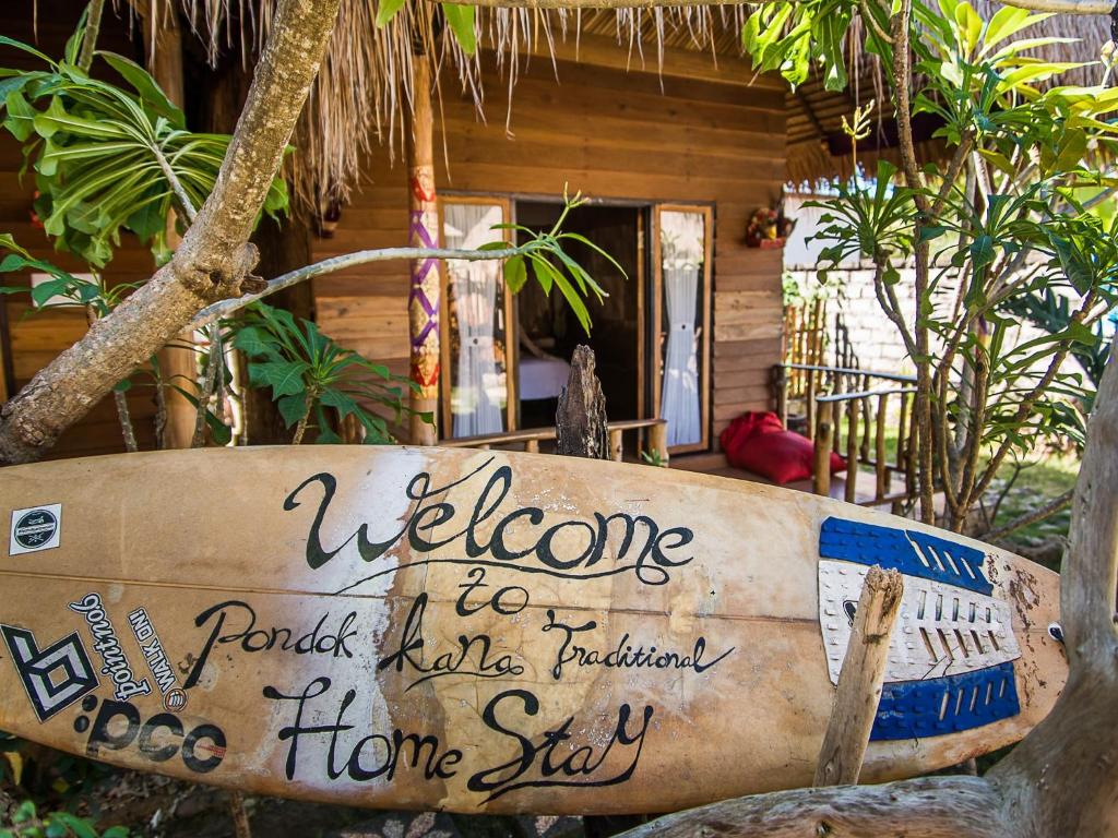 珀尼达岛Pondok Kana And Hostel by Ecommerceloka的坐在房子前面的冲浪板