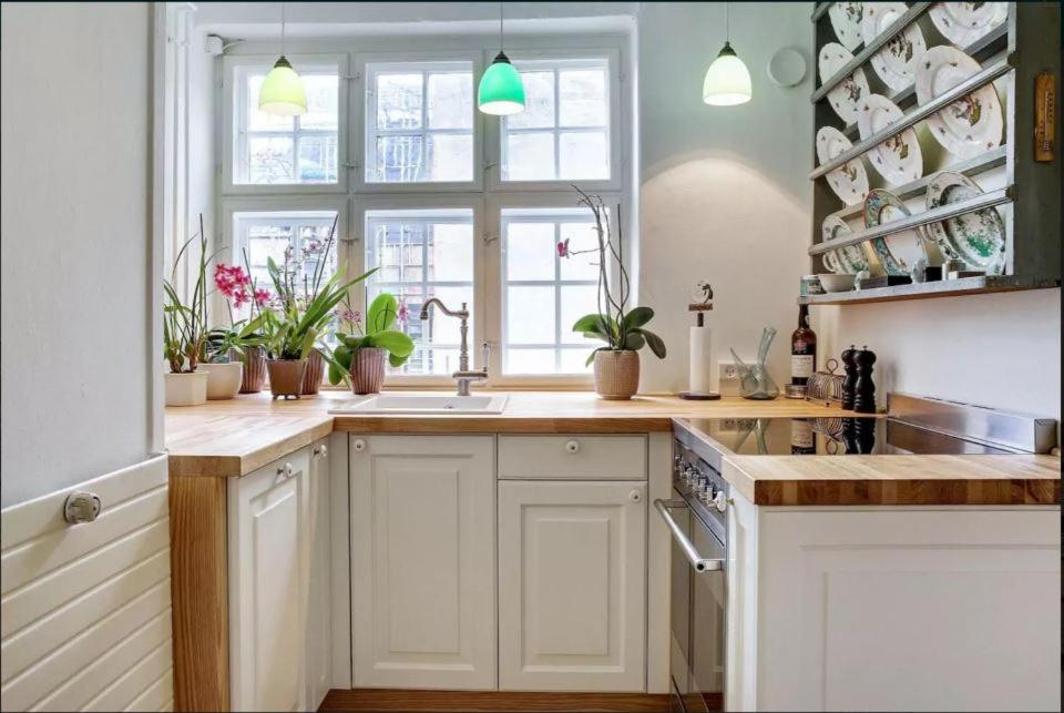 哥本哈根Central Danish apartment的厨房配有白色橱柜、水槽和窗户。