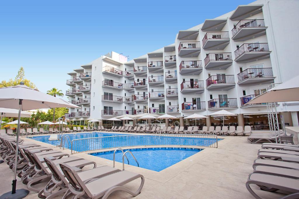 帕尔马诺瓦百慕大费格斯酒店的一座带游泳池和椅子的酒店和一座建筑