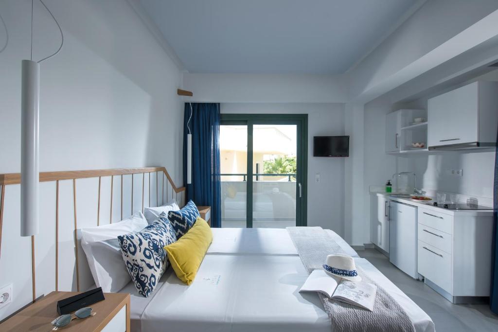 玛利亚Kristalli Hotel Apartments的一间带白色大床的卧室和一间厨房