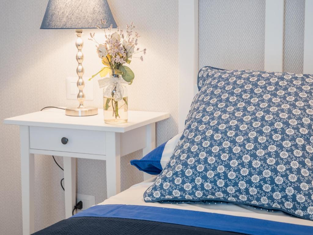 奥贝里塞Podere n°8 Agriturismo in Maremma的一张带蓝色枕头的床和一张带台灯的桌子