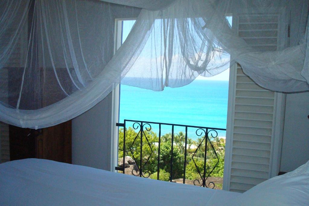 Five Islands VillageAloe Villa的一间卧室设有海景窗户
