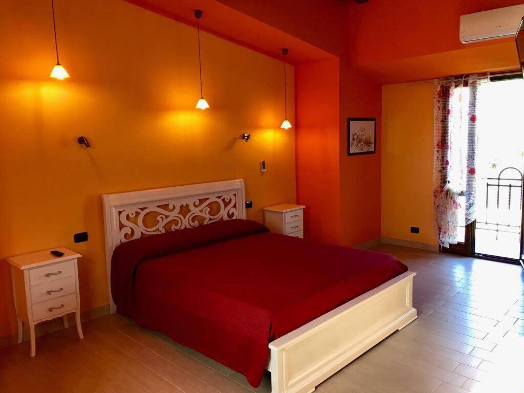 雷焦卡拉布里亚Eleven Bed & Breakfast的一间卧室设有红色的床和橙色的墙壁