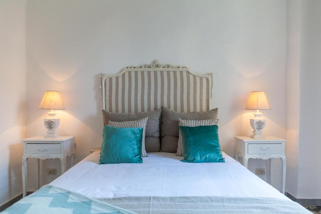 法萨诺Dimore del Faso的一间卧室配有一张带蓝色枕头的床和两盏灯。