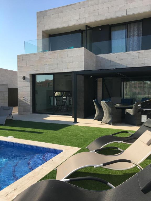 托雷帕切科Villa Mar menor Golf的现代房屋设有游泳池和庭院