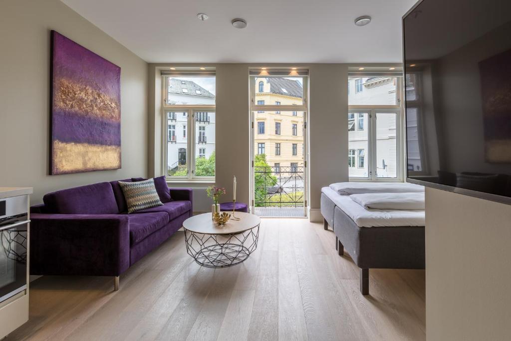 卑尔根2 Døtre Apartments的客厅配有紫色沙发和桌子