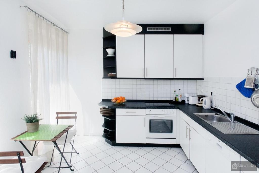 柏林Berlin Center的厨房配有白色橱柜、水槽和桌子