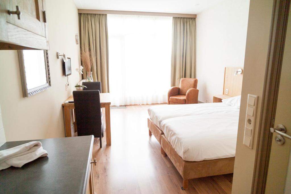 Middenbeemster贝姆斯特酒店的配有一张床和一张书桌的酒店客房