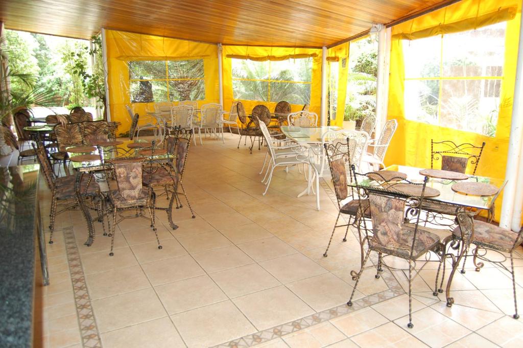 哈博罗内Falcon Crest Suites的户外庭院设有桌椅和窗户。