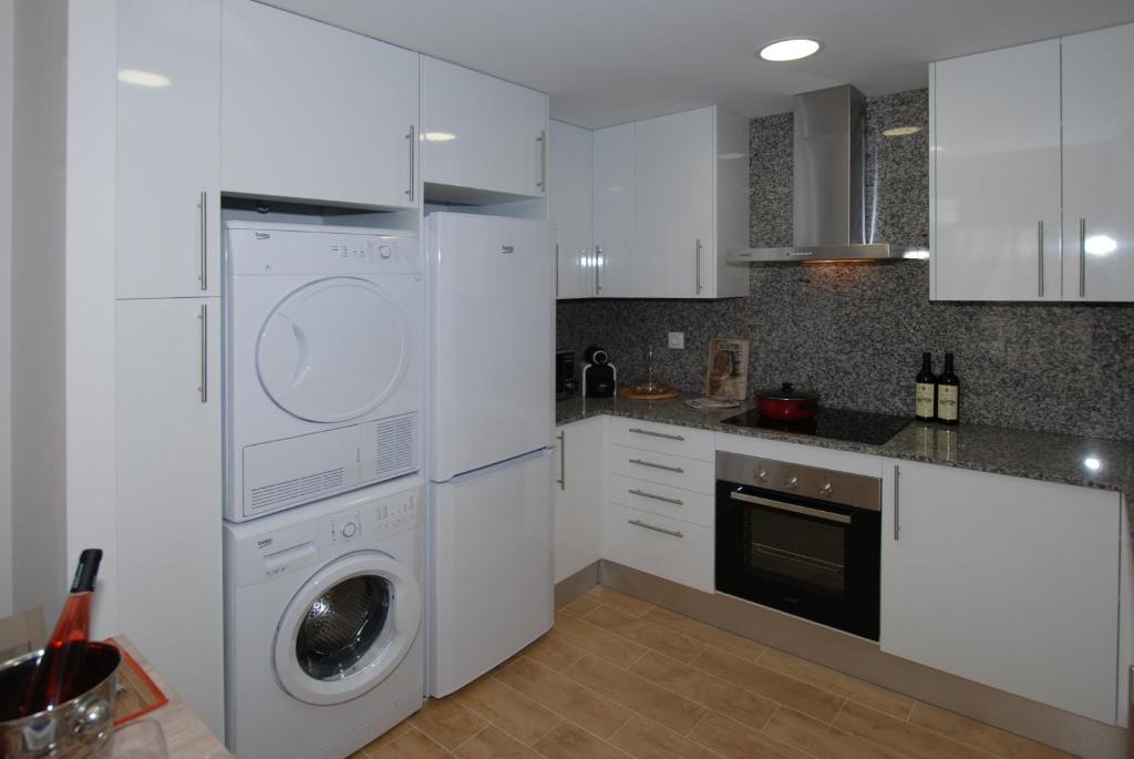 坎布里尔斯Apartments Gran VP的厨房配有白色橱柜、洗衣机和烘干机