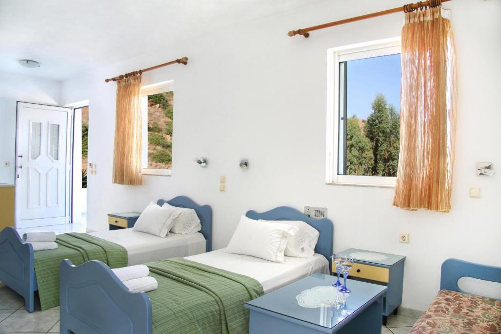 罗达奇诺Kleanthis Apartments的客房设有两张床、一张沙发和窗户。