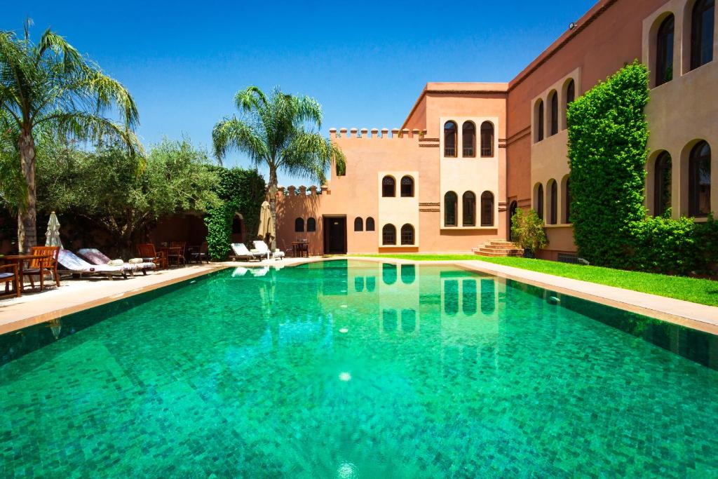 马拉喀什阿尔法希亚阿古达尔酒店的房屋前的游泳池