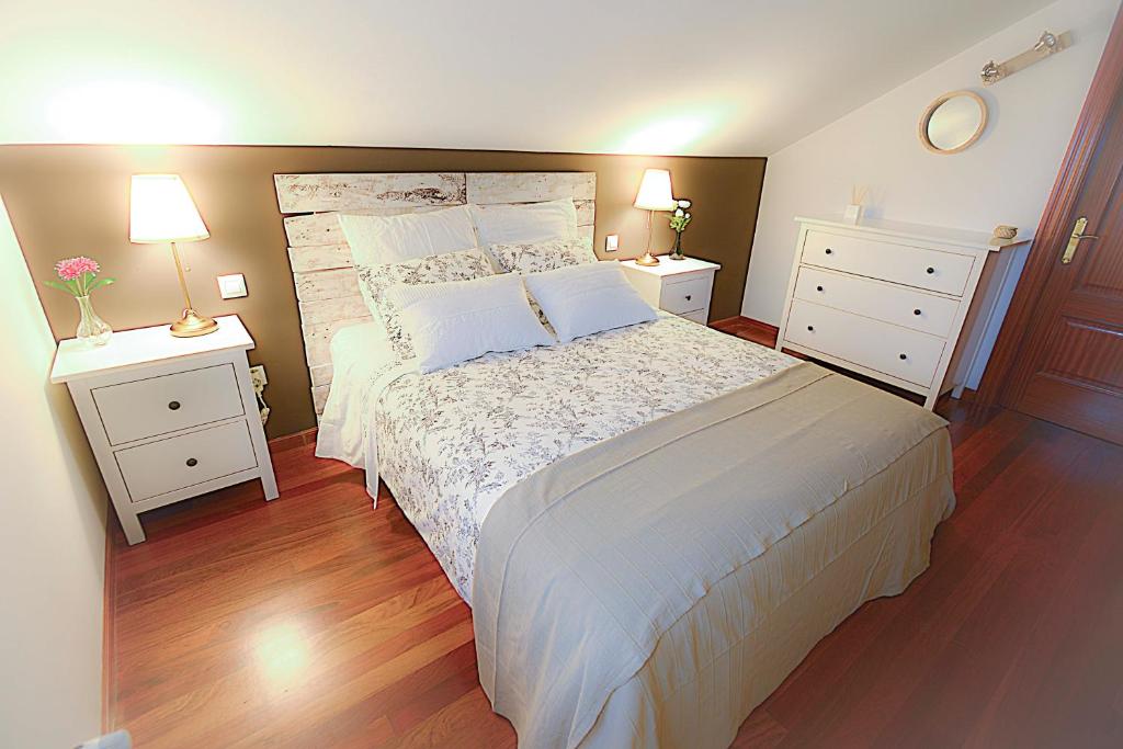 苏安塞斯Chalet junto a playa de Suances的一间卧室配有一张带2个床头柜的大床