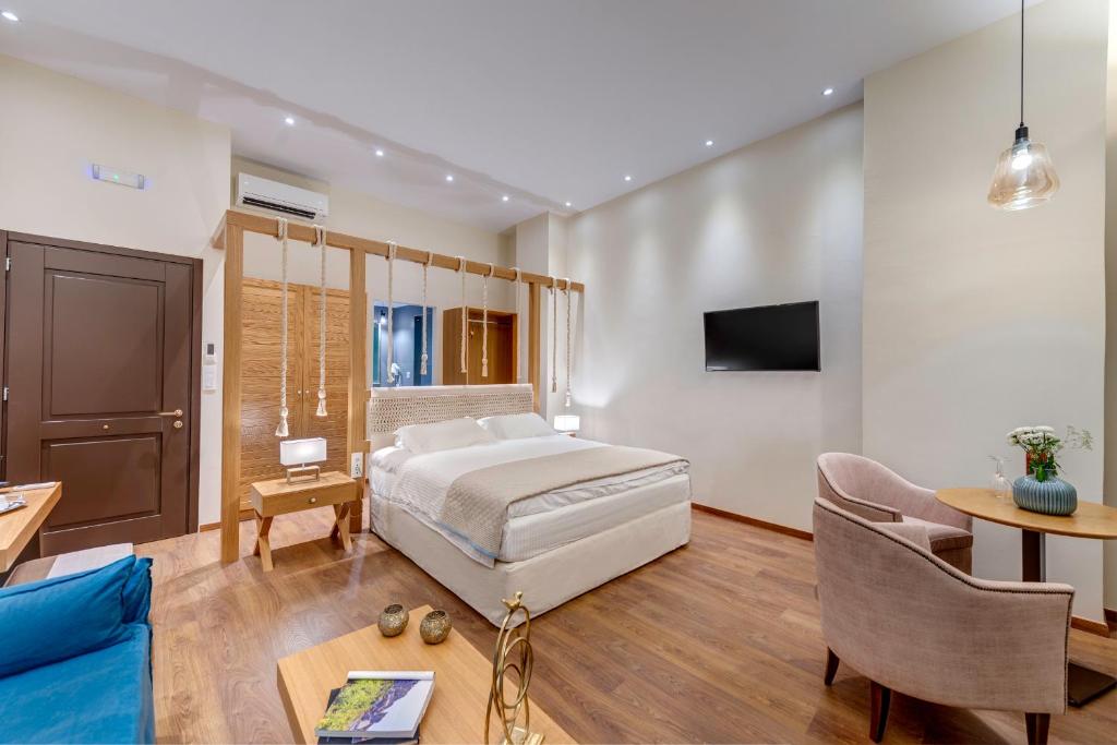 埃尔莫波利斯1844 Suites Syros的一间卧室设有一张床和一间客厅。