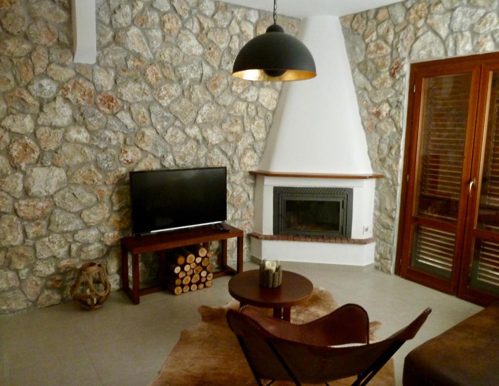 尼基季Beach House Nikiti的一间带电视和石墙的客厅