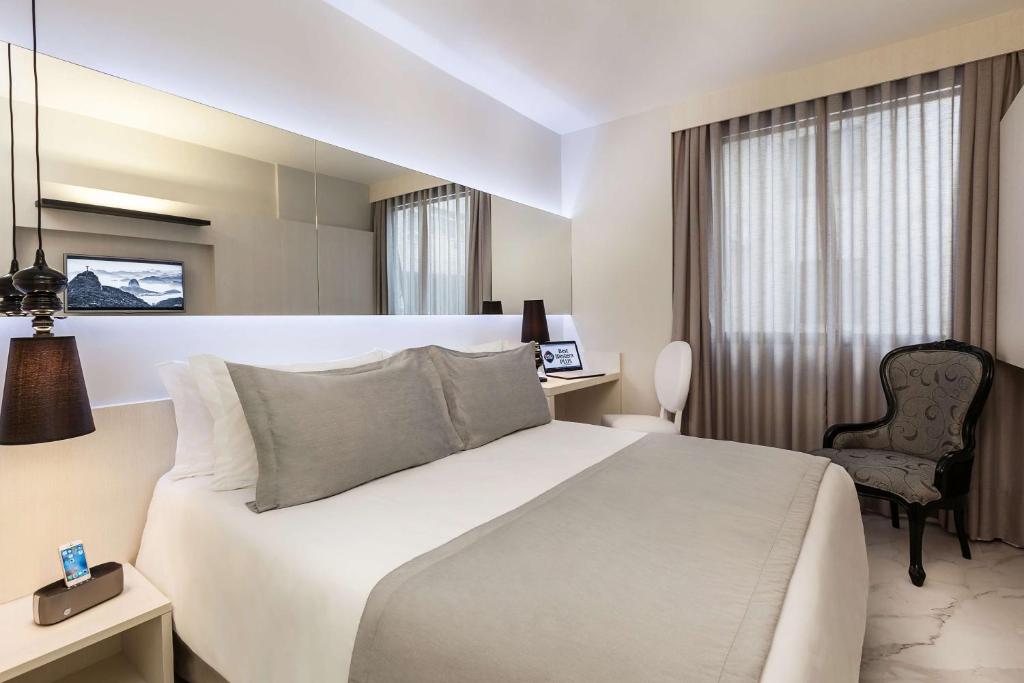 里约热内卢Nobile Hotel Copacabana Design的配有一张床和一把椅子的酒店客房