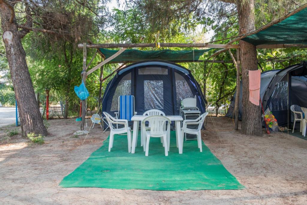 锡基亚Camping Pitsoni的绿色地毯上的帐篷,配有桌椅