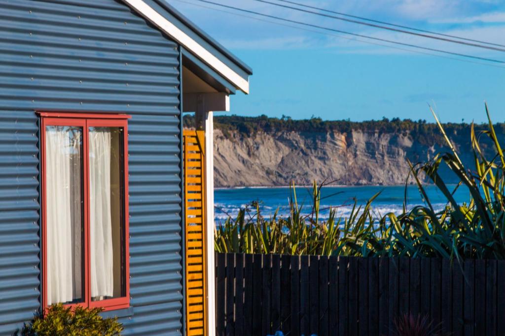 格雷默斯BeachView Motel的一座带红色窗户和栅栏的房子