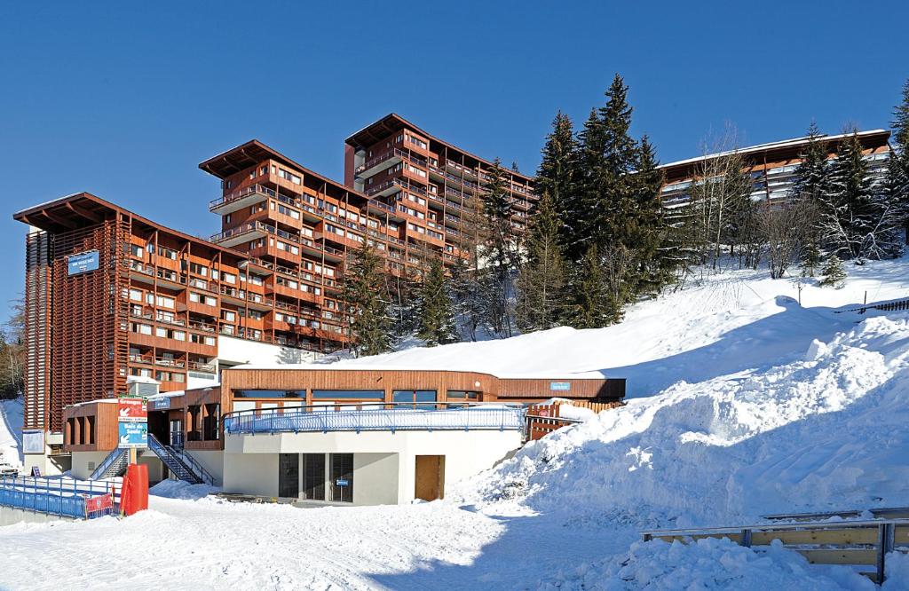 阿克 1600travelski home premium - Résidence Le Roc Belle Face 4 stars的一座大建筑,位于一座白雪覆盖的山顶上