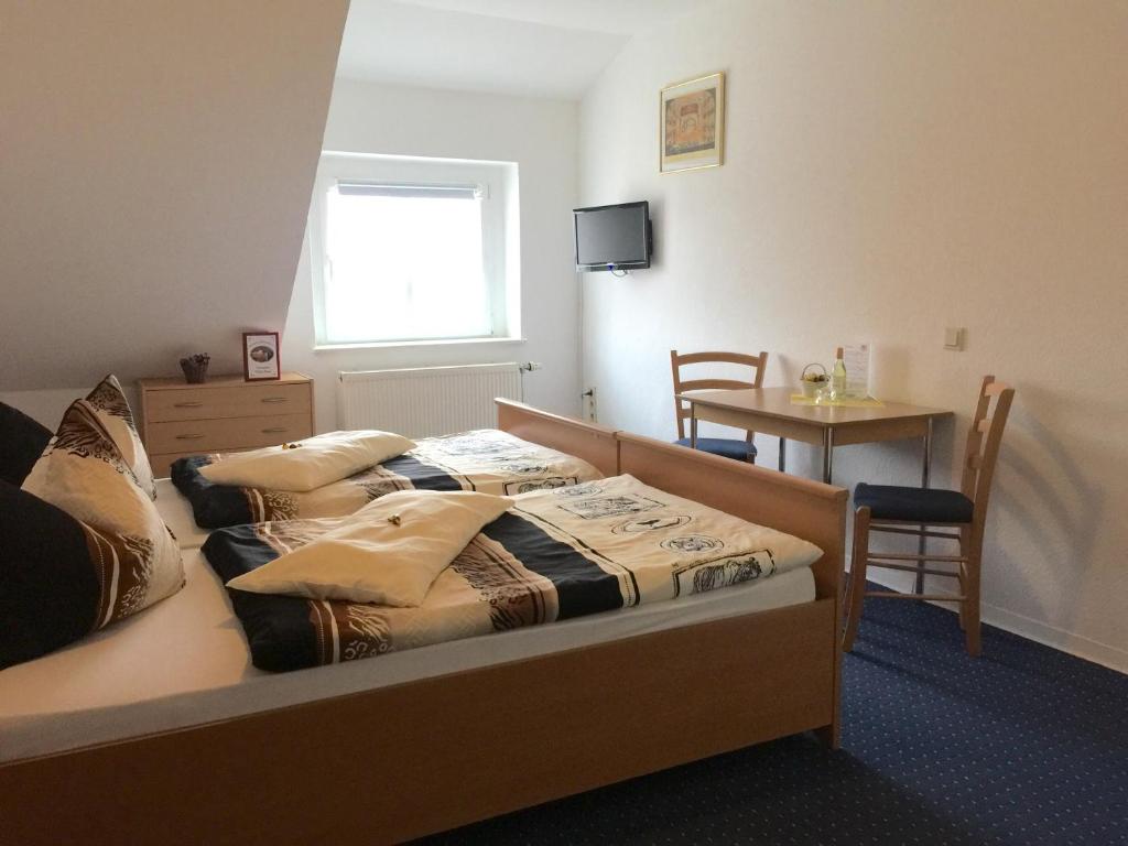 海德瑙厄尔斯酒店的一间卧室配有一张带枕头和桌子的床