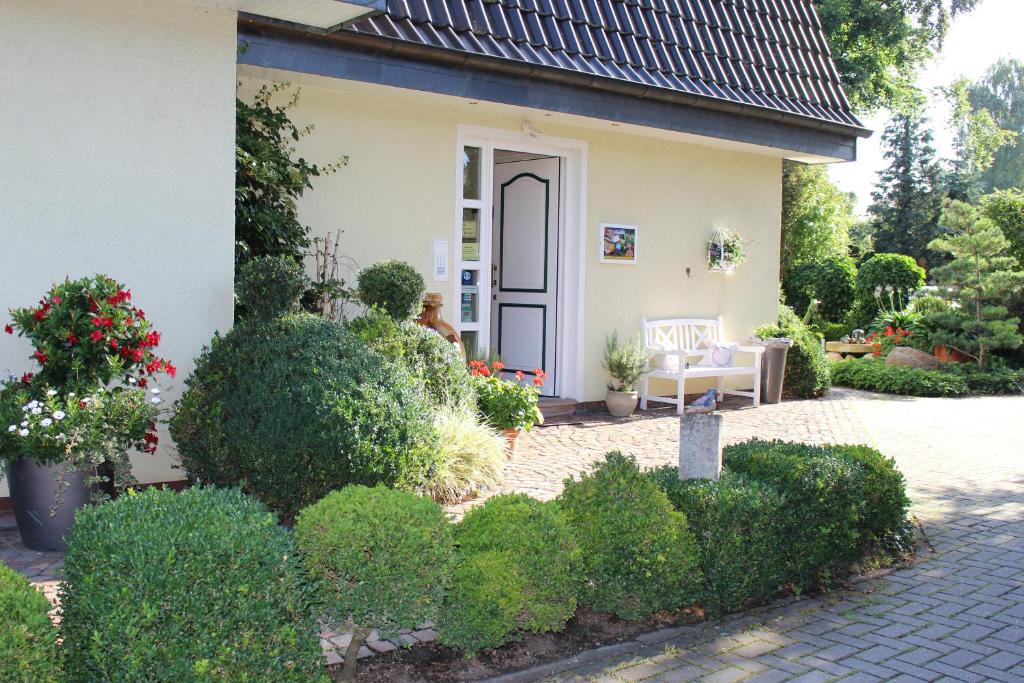 瓦伦多夫Gästehaus Niemerg的一座带庭院和灌木的小房子