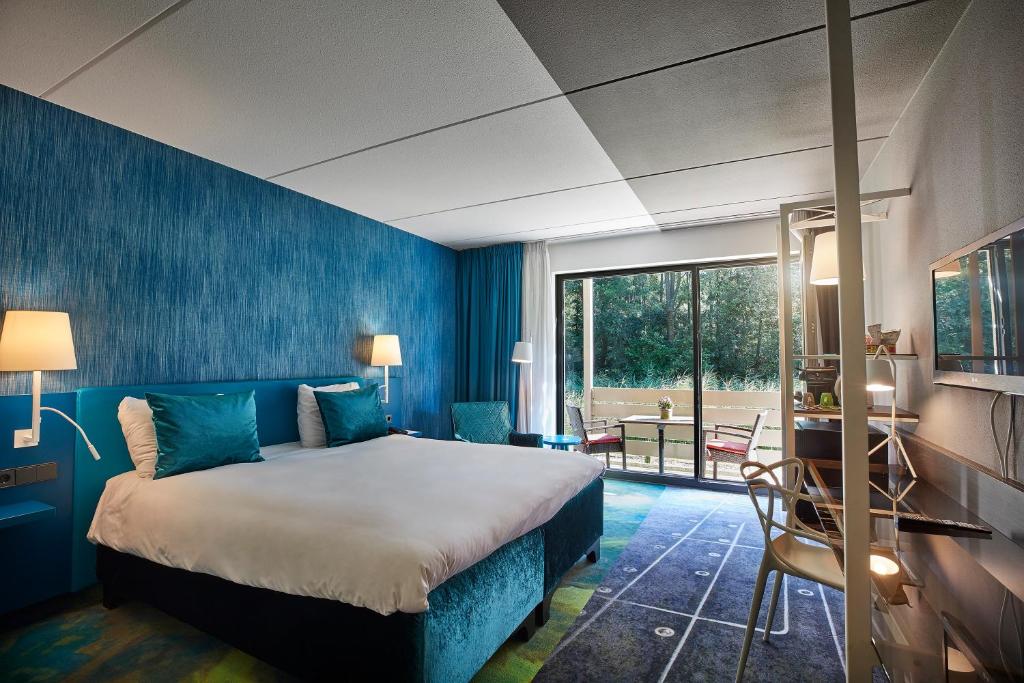 乌得勒支卡尔顿总统的一间卧室设有一张床和蓝色的墙壁