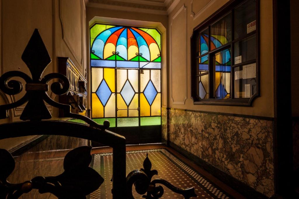 米兰布罗尼佐之家旅馆的一间设有彩色玻璃窗和楼梯的房间
