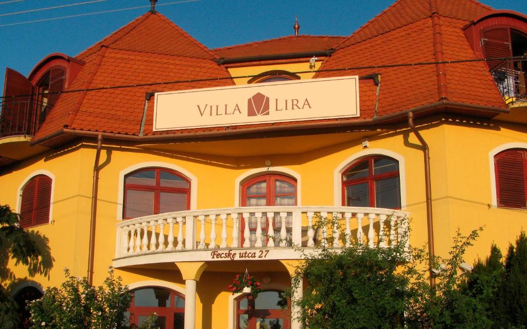 赫维兹Villa Lira的黄色的建筑,上面有读别墅小字的标志